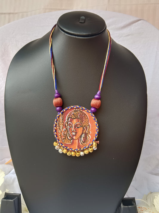 Necklace with a decorative pendant on a black mannequin bust.
